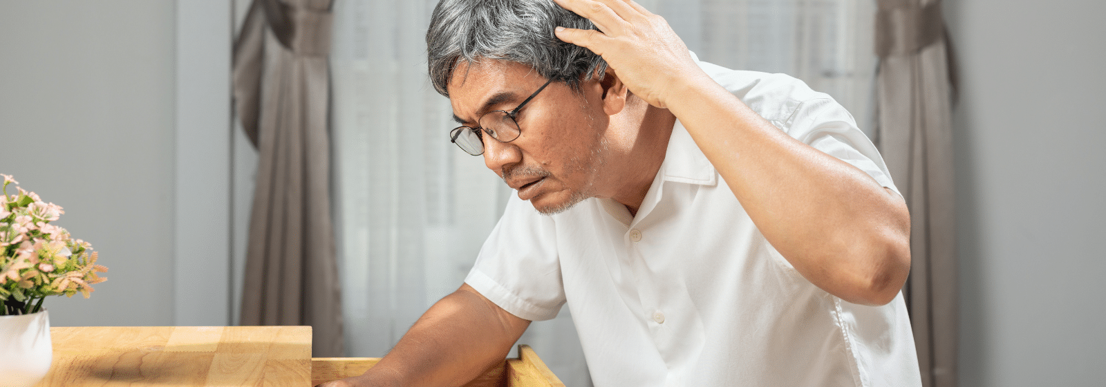 Personne âgée masculin qui se touche la tête avec un regard inquièt
